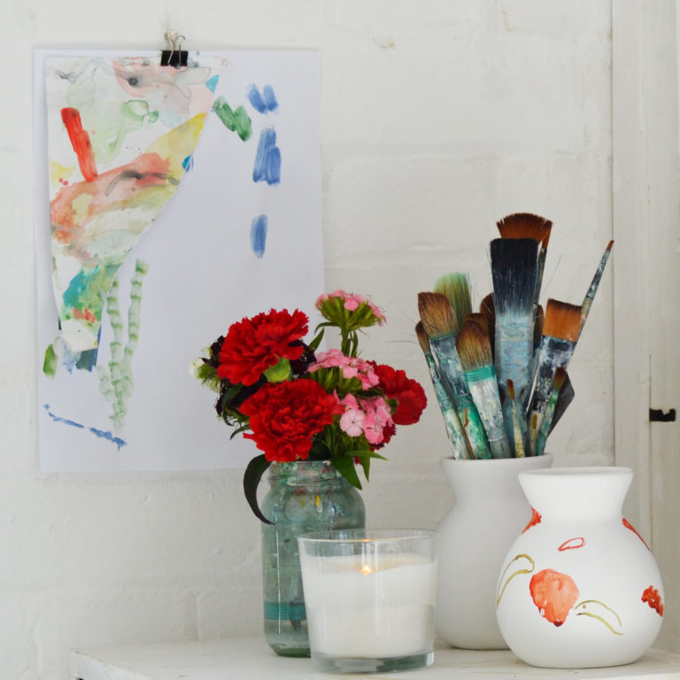 Paintbrushes and flowers in Laura's studio